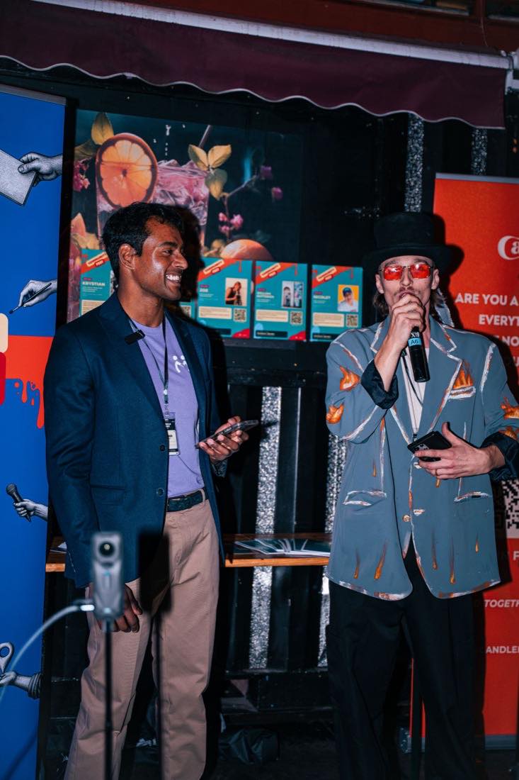 Hosting duties, in front of the banners.