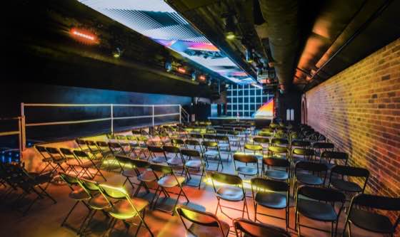 FIRE Main Room — warmly lit arch with seating facing a stage