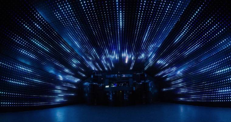 A DJ booth in front of a huge blue LED light wall